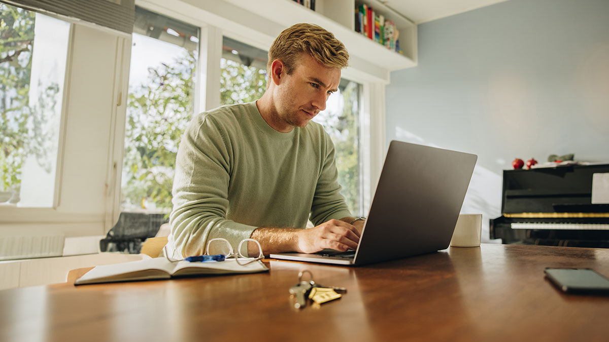 jovem sentado ao computador a fazer o pagamento do IMI